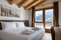 Camera di un B&B di montagna con asciugamani sul letto